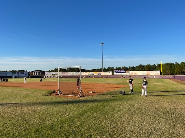 Players fielding balls during batting practice.
