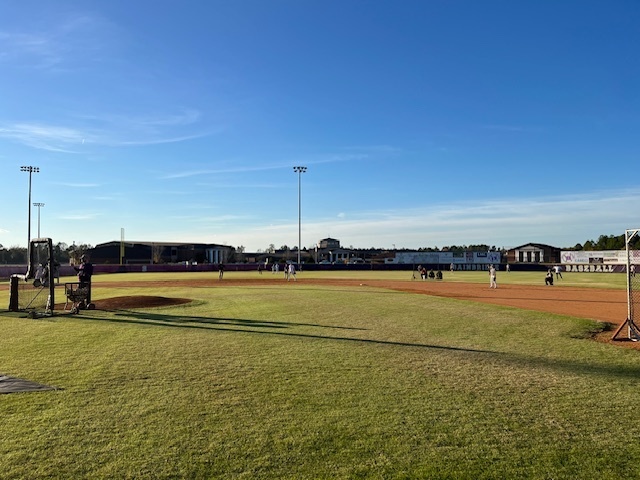 Players fielding balls during batting practice.