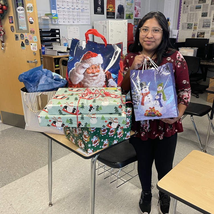 Anchor Club member Angelica DeJesus poses by the gifts for the residents at Memorial Manor some club members adopted for Christmas. 