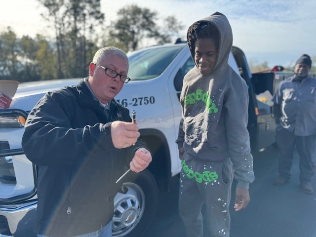 Jeff Lynn with Delta Tire helps a student to see the different aspects of checking tire pressure.