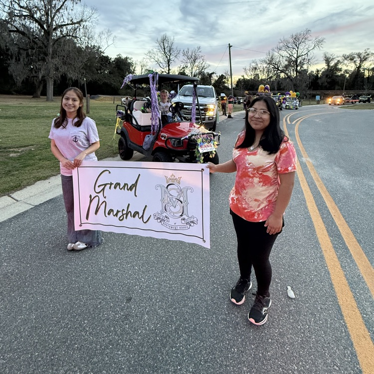 Anchor Club members Angelina Gomez-Roman and Angelica DeJesus helped usher in the Grand Marshal at the Mardi Gras parade.