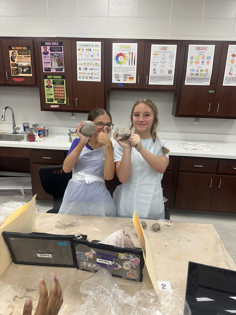 8th Grade students showing their artwork with clay.