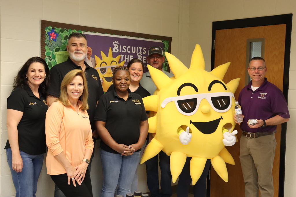 SunStop team and school staff pose with Sunny the mascot at a Biscuits for the Best teacher appreciation event.