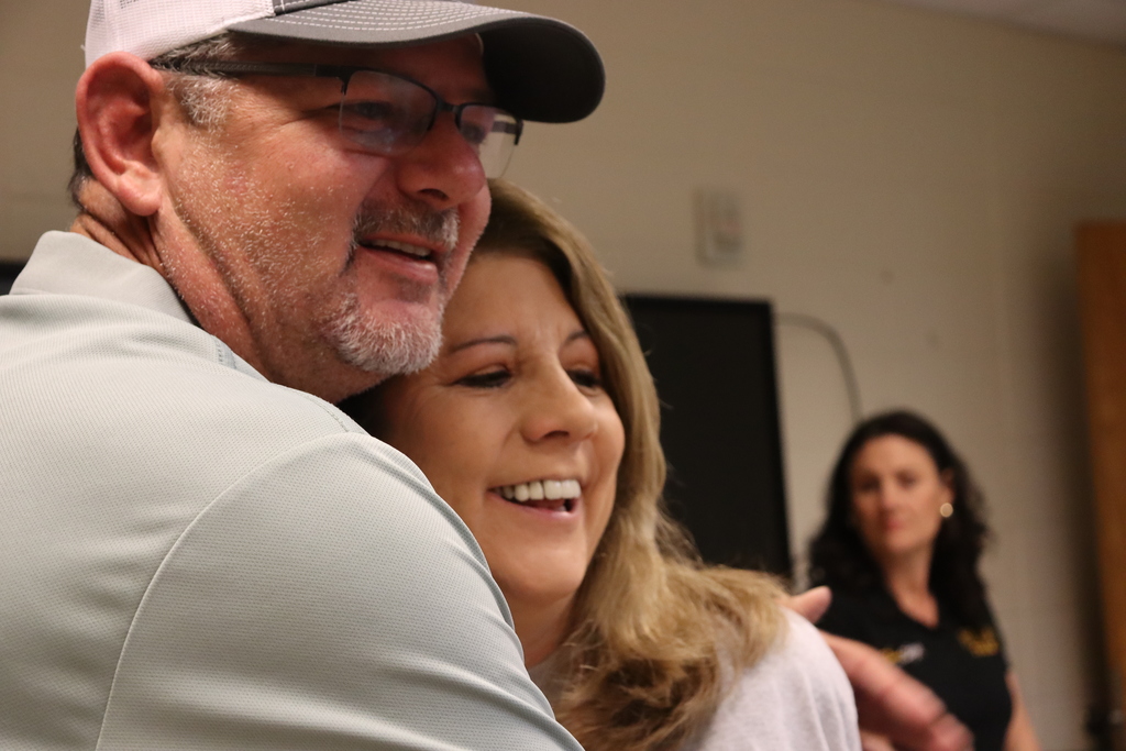 Two staff members share a hug and smile during a teacher appreciation event.