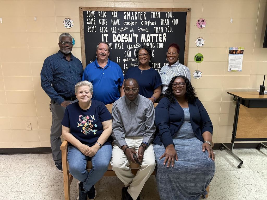 Staff members wearing blue pose for a picture