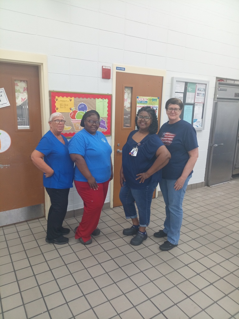 Staff members wearing blue pose for a picture