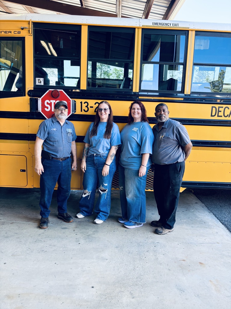 Staff members wearing blue pose for a picture