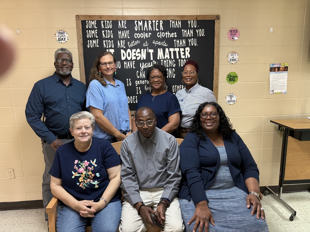 Staff members wearing blue pose for a picture