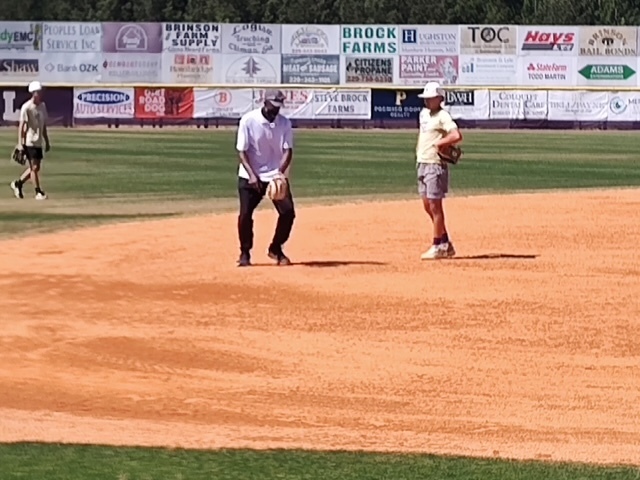 Alum Ernest Riles giving some pointers to Bearcats starting shortstop Benji Dollar.