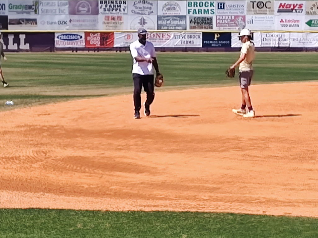 Alum Ernest Riles giving some pointers to Bearcats starting shortstop Benji Dollar.