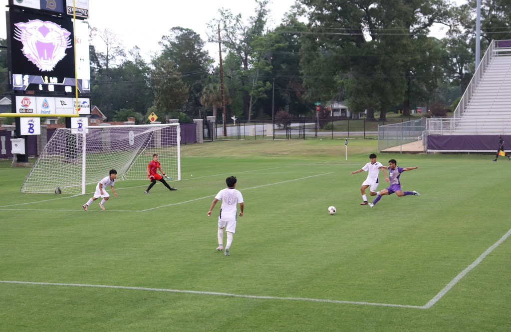 bhs soccer player dressed in purple uniform plays game taking on opponent in white uniform