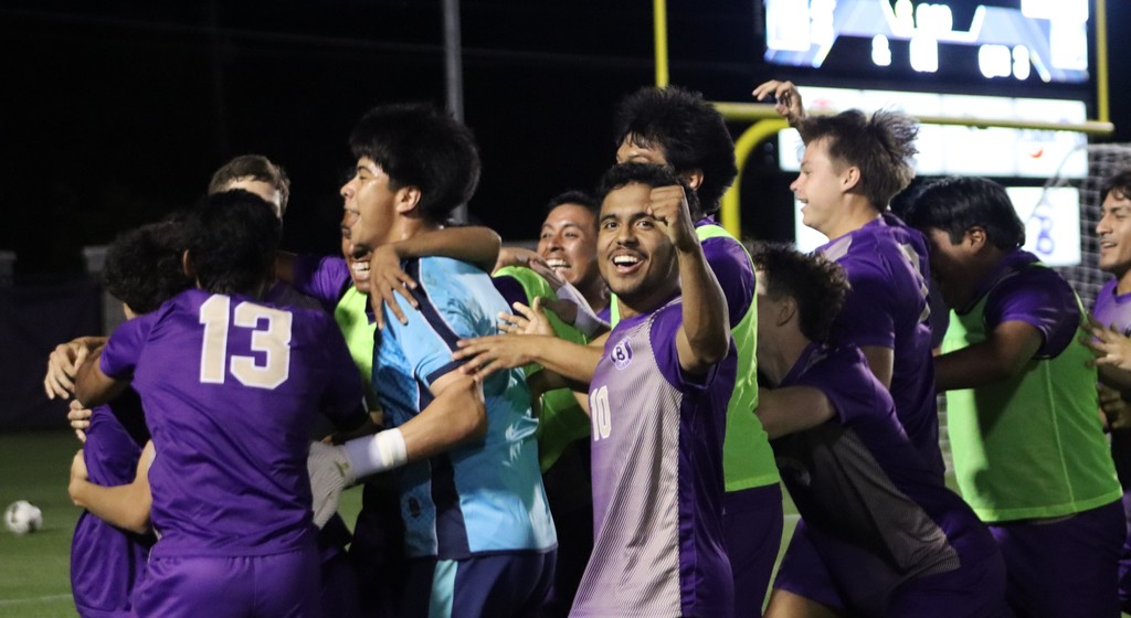 bhs soccer player dressed in purple uniform plays game taking on opponent in white uniform