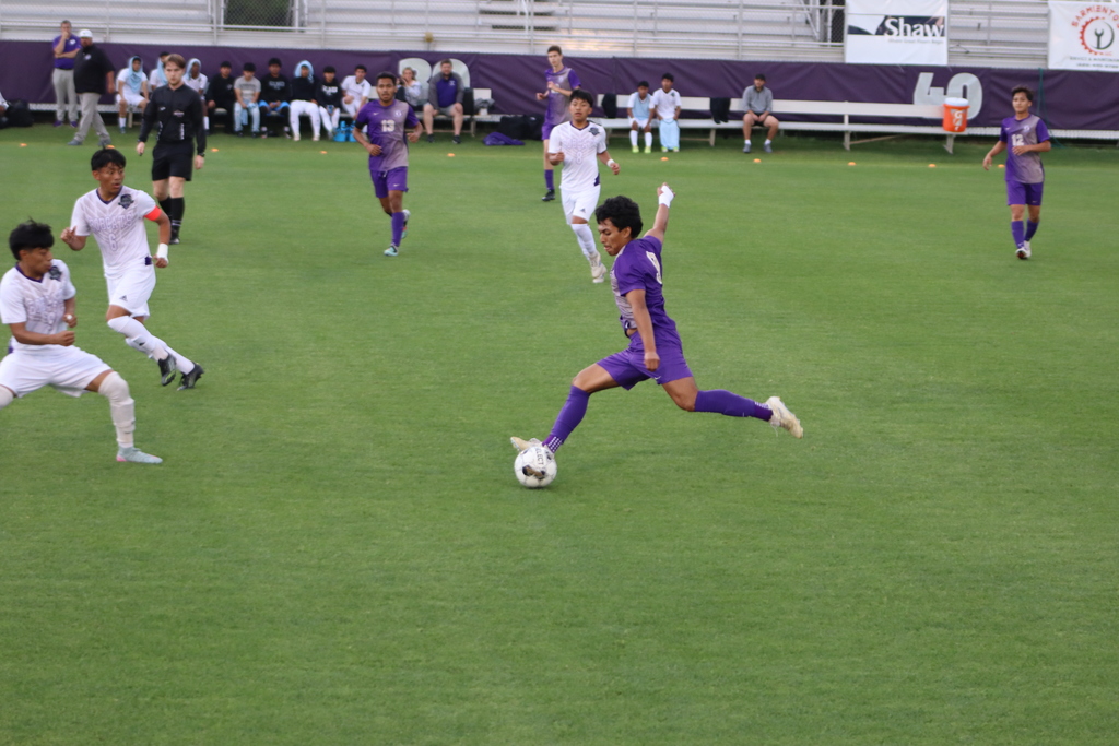bhs soccer player dressed in purple uniform plays game taking on opponent in white uniform