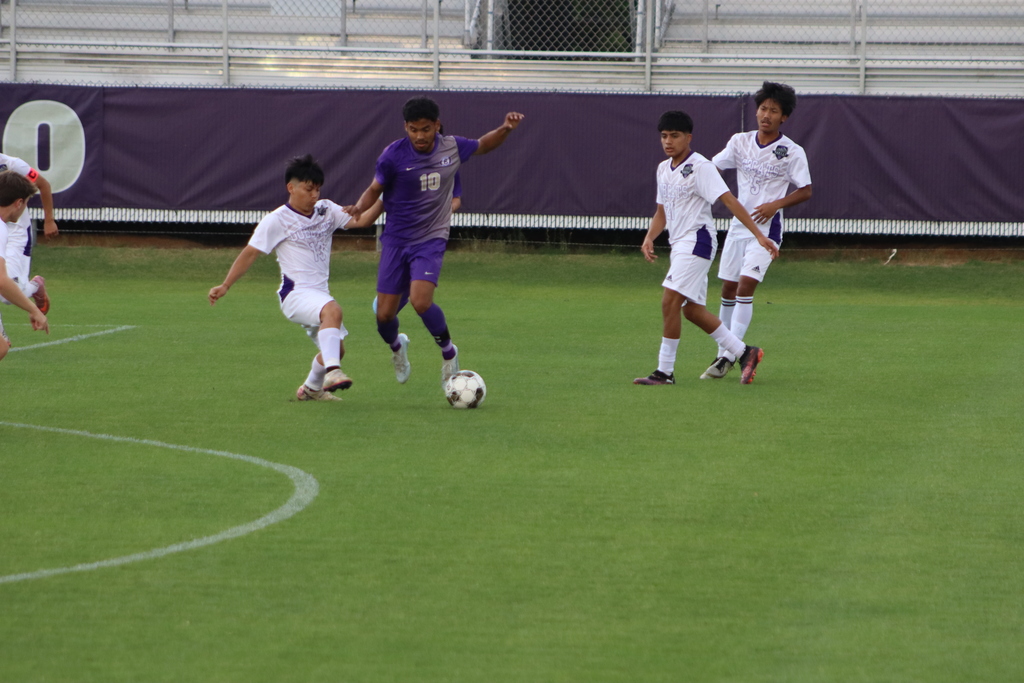 bhs soccer player dressed in purple uniform plays game taking on opponent in white uniform
