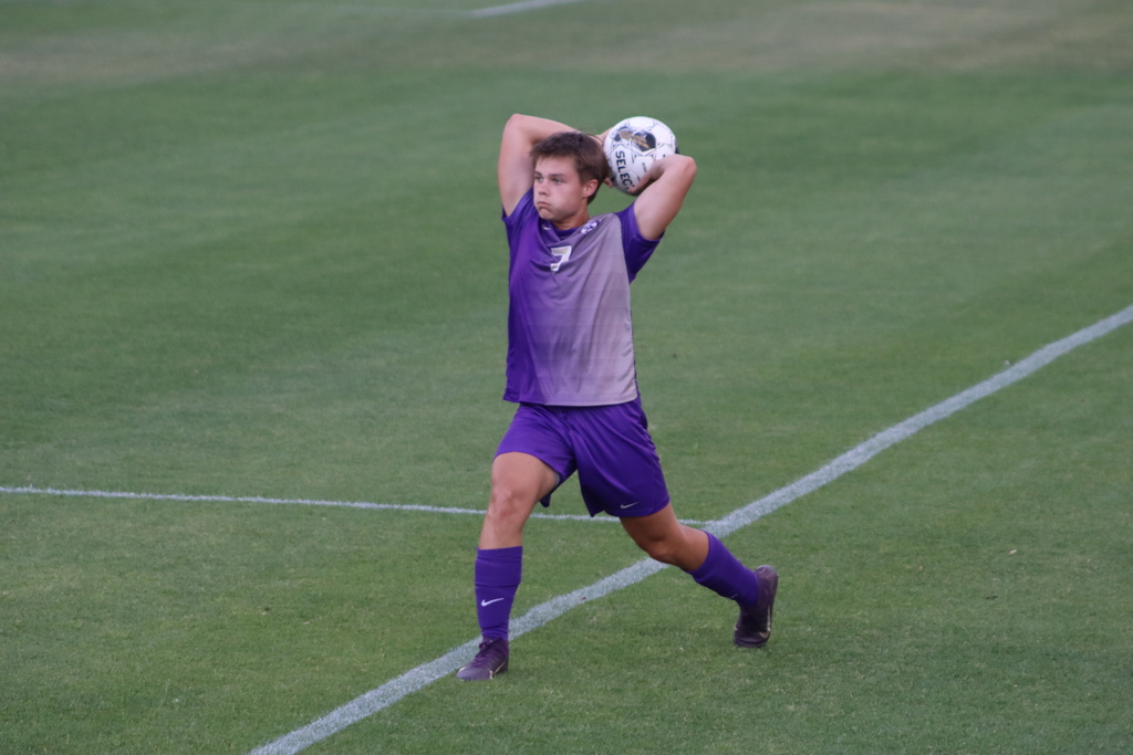 bhs soccer player dressed in purple uniform plays game taking on opponent in white uniform