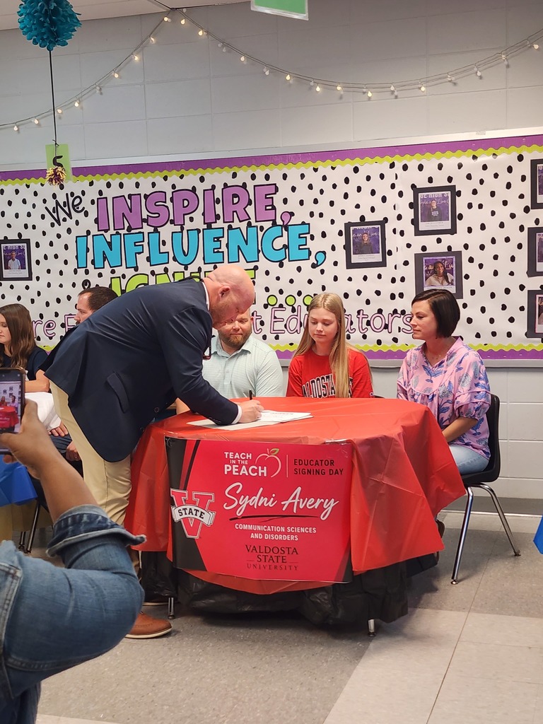 Principal Bryant signing in support of Teach in the Peach day