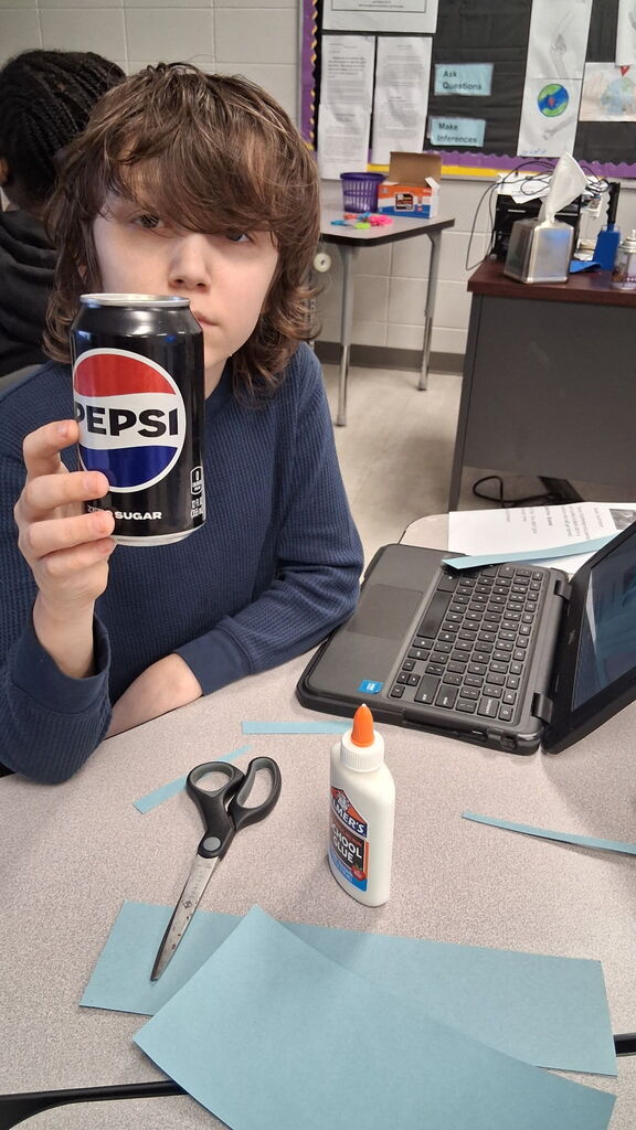 Students in Mrs. Crawford's class decorated empty soda cans describing characters in a story. 