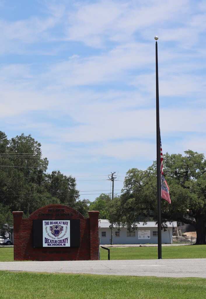 Flags at half-staff outside the Decatur County Schools sign in honor of Peace Officers Memorial Day.