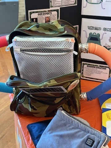 A series of photos shows three middle school students participating in a STEM and innovation event at a museum. The students explore interactive exhibits, including a flight simulator and historical automobile displays, while learning about engineering and technology. They examine informational exhibits, speak with event organizers and judges about STEM projects, and view a prototype backpack designed with ventilation and cooling features. Additional photos show the students receiving event materials, engaging in discussions about their project, and posing outdoors beside a large Abraham Lincoln mascot figure. The images capture hands-on learning, teamwork, problem-solving, and student engagement in science, technology, engineering, and innovation activities.