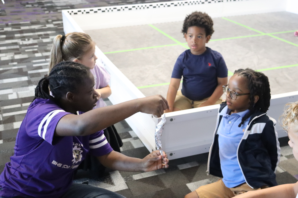 A student mentor demonstrates an engineering activity to campers during Summer STEM Camp.