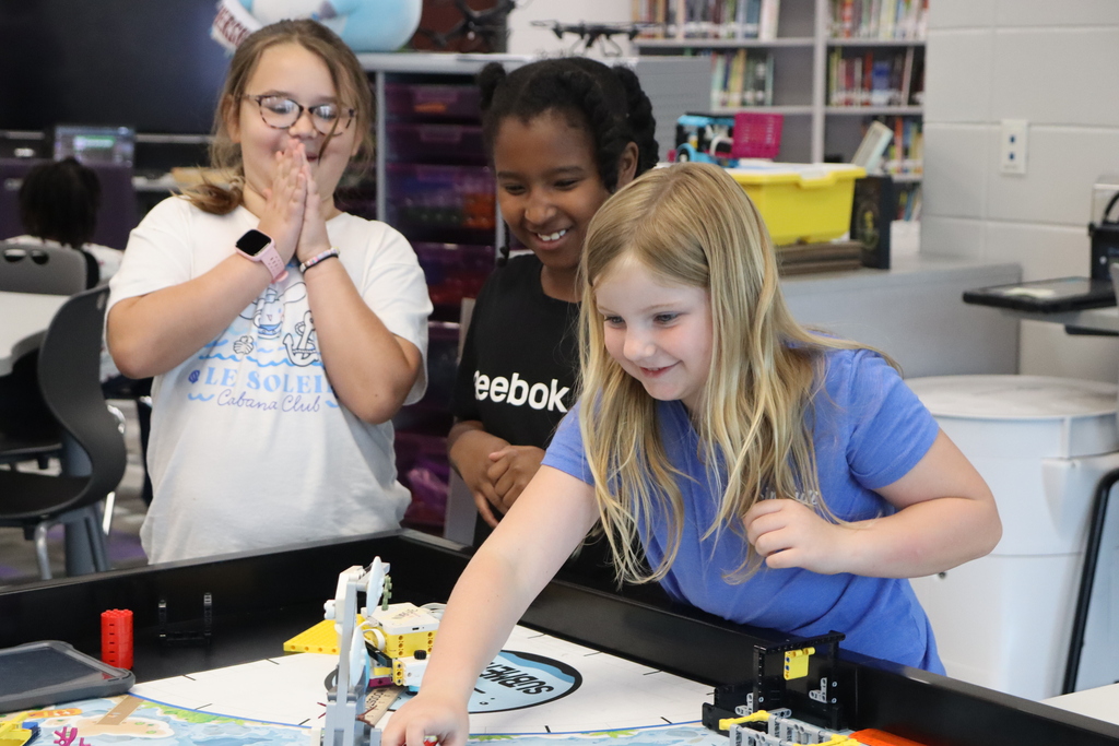 Students cheer as a classmate tests a LEGO robot during Summer STEM Camp.