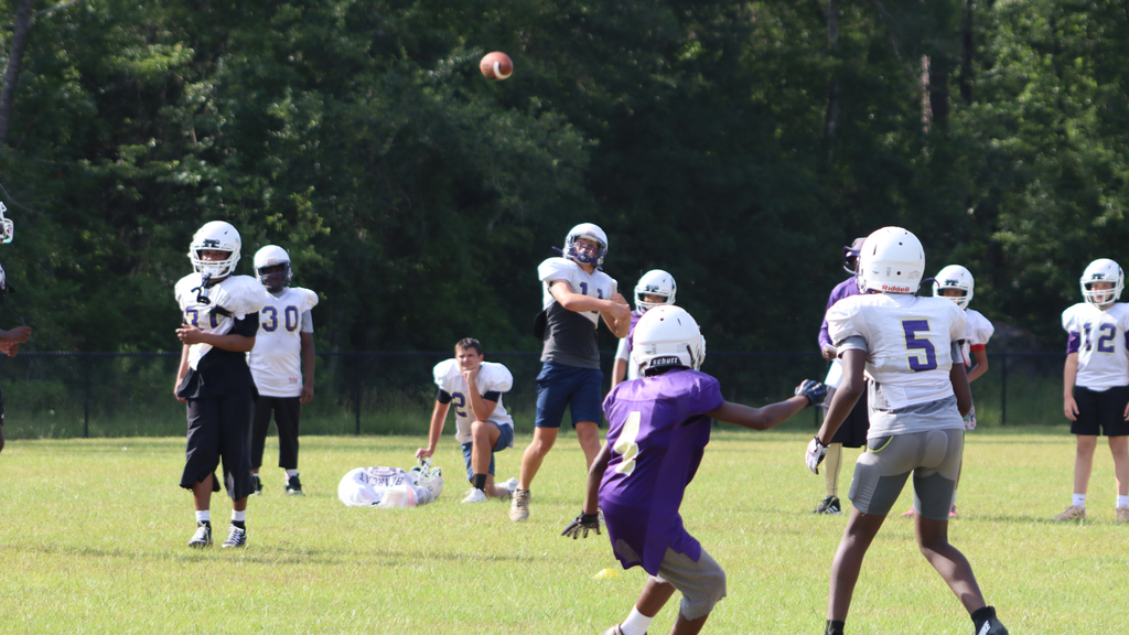 Bearcat football players gather during summer practice.