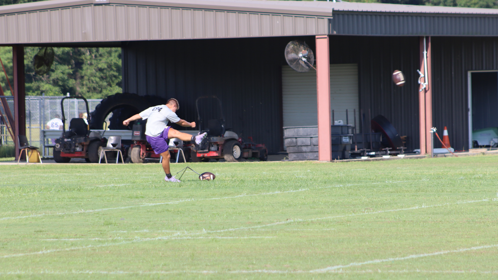 Football player practices kicking on the BHS field.