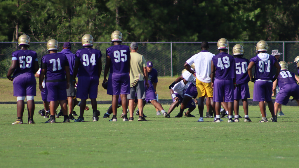 Bearcat football players gather during summer practice.