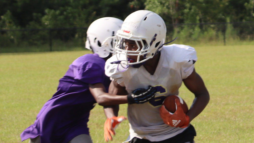 Bearcat football players gather during summer practice.