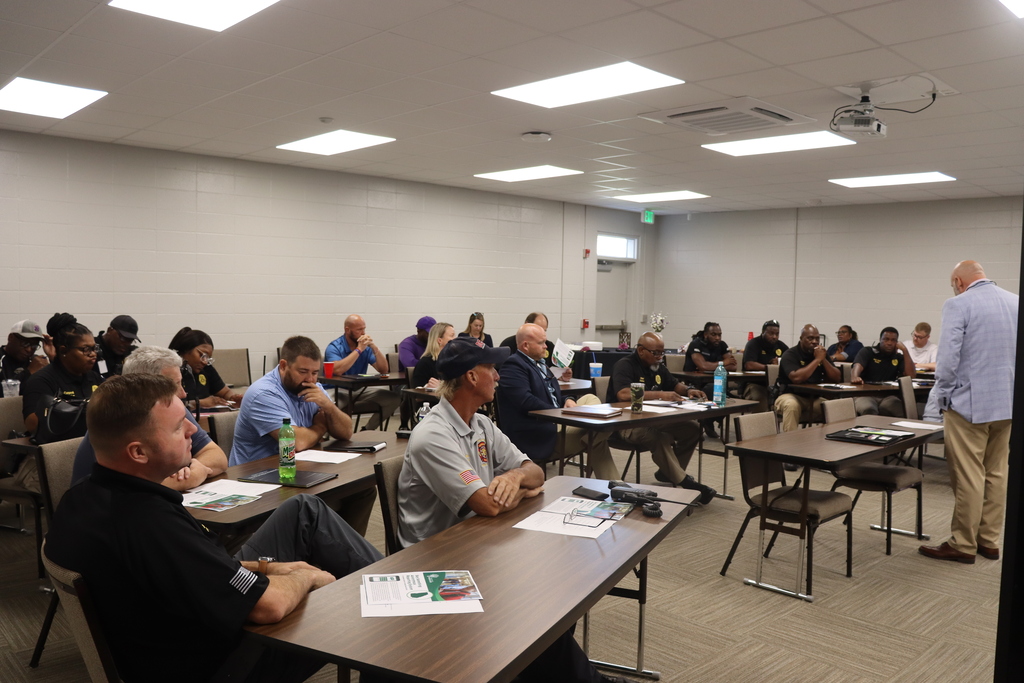 School safety personnel and staff participate in a professional training session in a classroom.