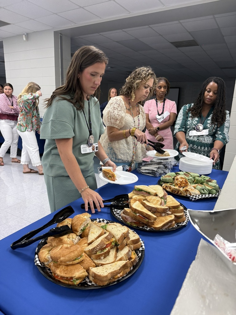 New Decatur County Schools teachers move through the lunch line, choosing from trays of sandwiches and wraps provided by First Port City Bank.