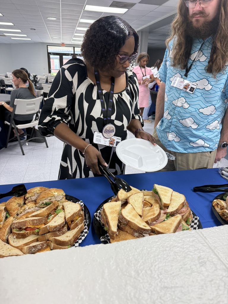 New Decatur County Schools teachers select sandwiches from trays at the catered lunch provided by First Port City Bank.