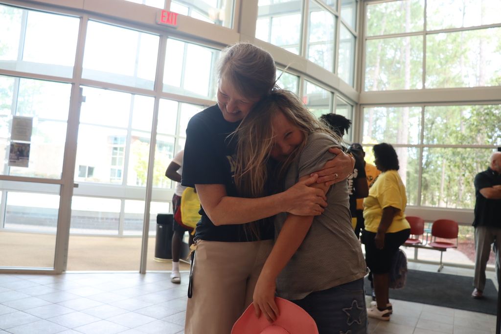 A DCBOE staff member shares a warm hug with a student at Bearcat Blitz.