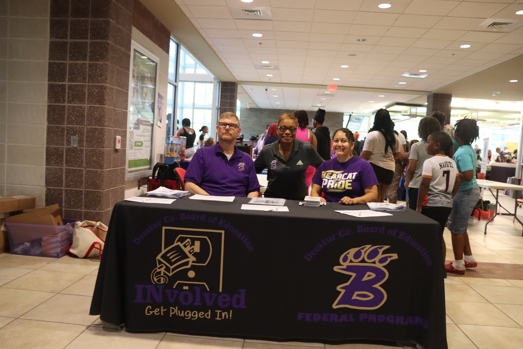 Three DCBOE staff members welcome families at the Bearcat Blitz community event.