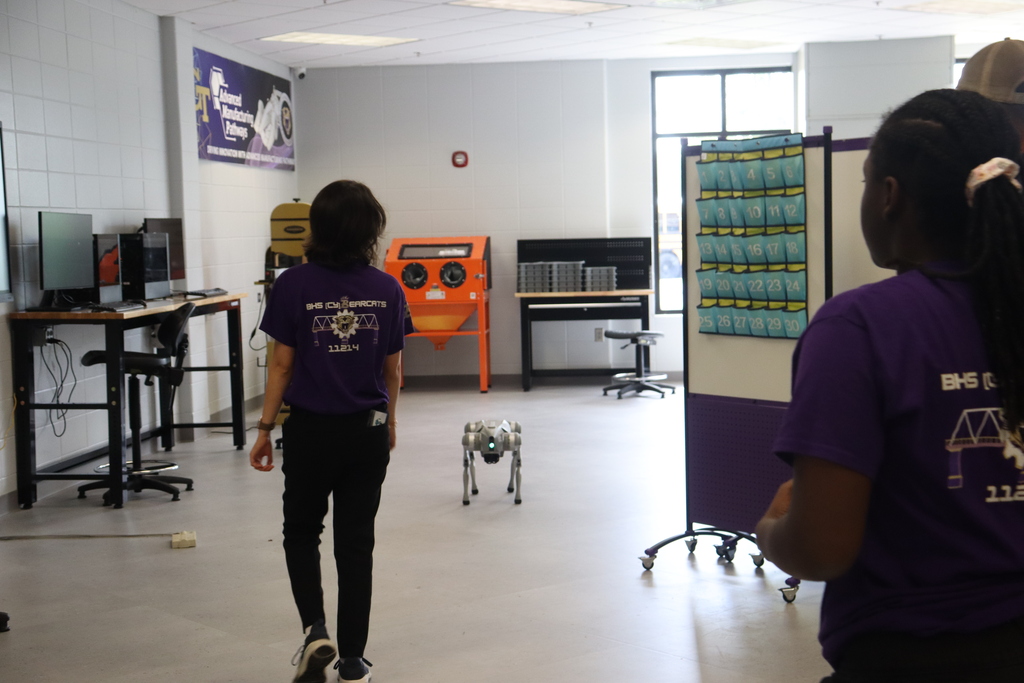 IMG_1064.JPG: Educators watch a robotic dog demonstration in a technology lab.