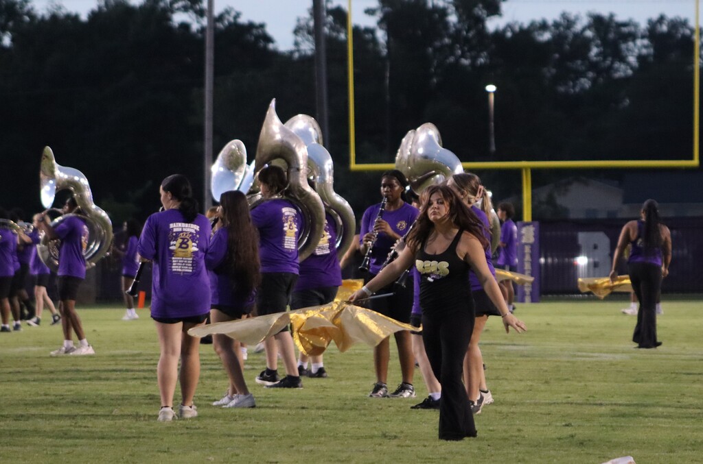 High school students, football players, cheerleaders, marching band members, and fans gather at Centennial Field for a Bearcats game day and school spirit event.