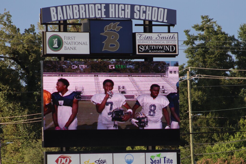 High school students, football players, cheerleaders, marching band members, and fans gather at Centennial Field for a Bearcats game day and school spirit event.