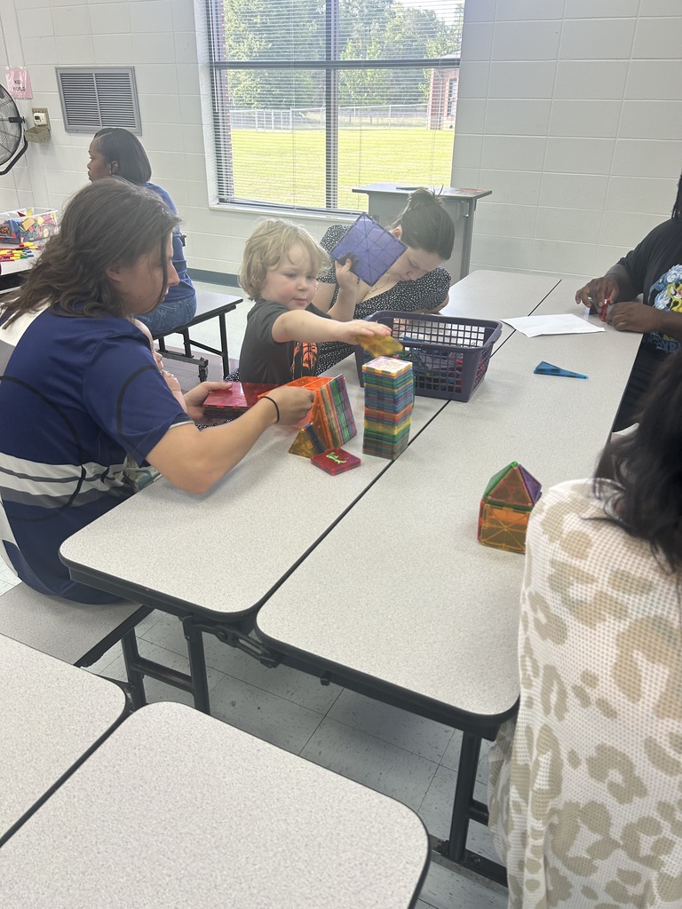 A child and family members explore colorful magnetic tiles during Pre-K Orientation.