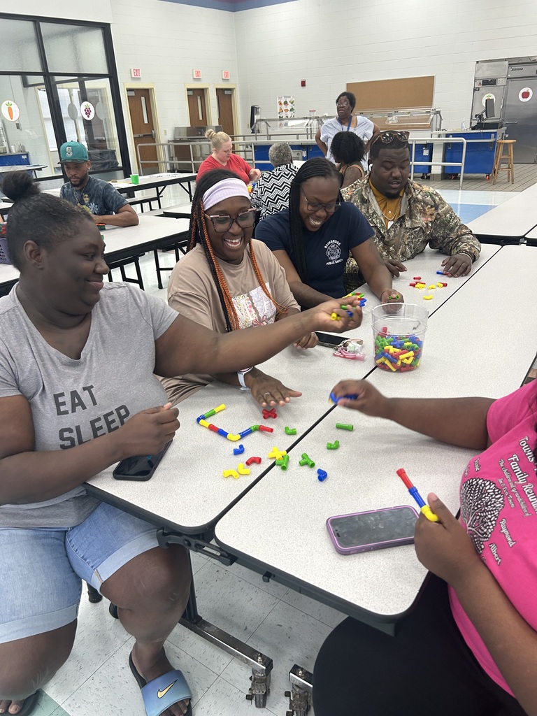 Pre-K families smile and work together with colorful learning materials.