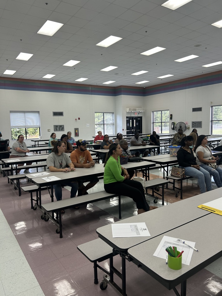 Pre-K families gather in the cafeteria for an orientation presentation.