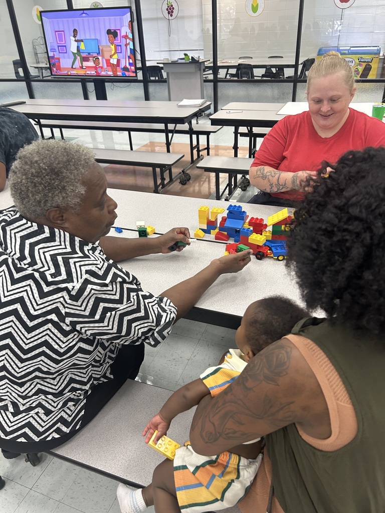 Pre-K families smile and work together with colorful learning materials.