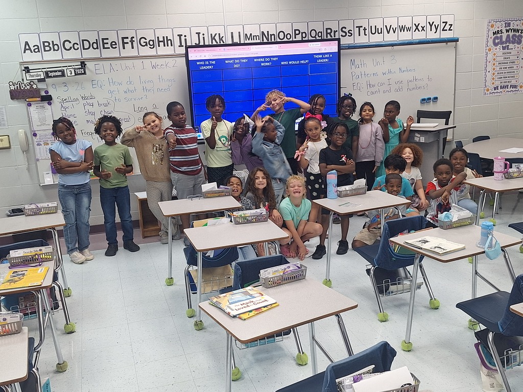 Mrs. Wynn's students in front of the Jeopardy Board