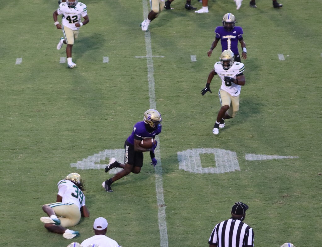 Bearcat football player runs with the ball during the game.