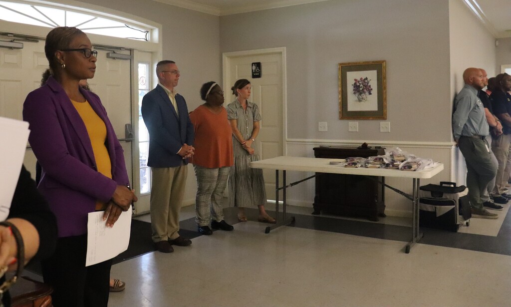 community members particpate in event at community center, engaging in conversation and shaking hands