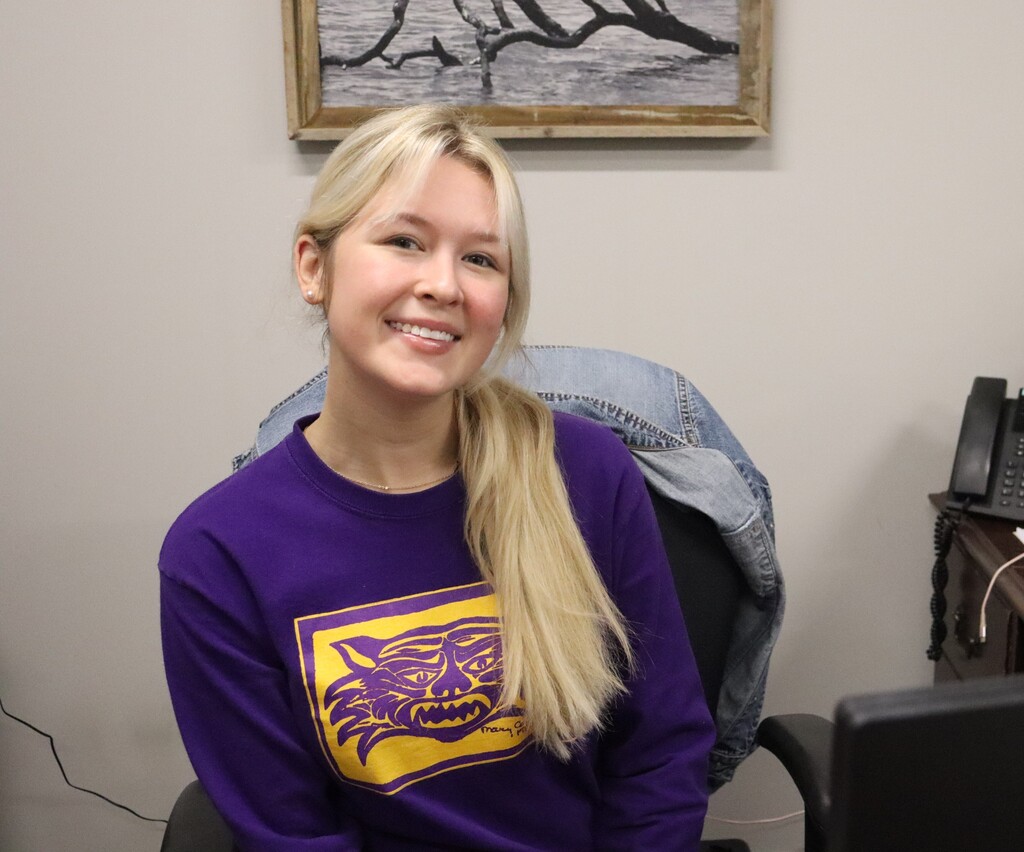 woman in purple bearcat shirt smiles for a picture