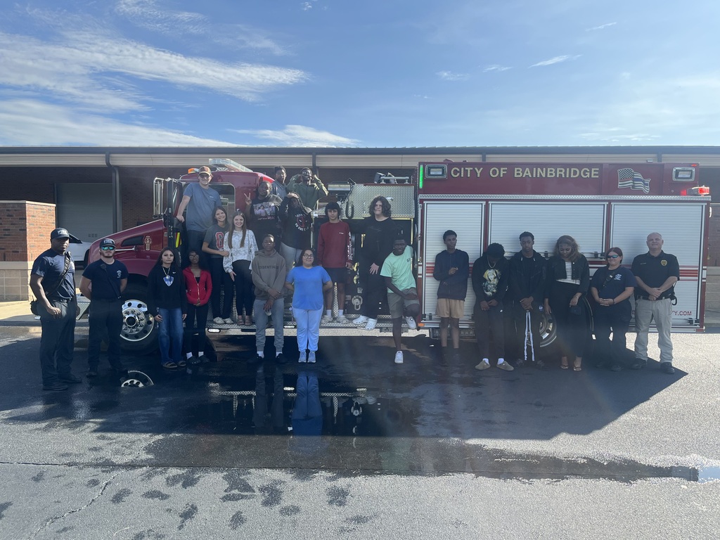Students in the Introduction to Law and Criminal Justice Essentials classes participate in a hands-on learning experience with City of Bainbridge Fire personnel, practicing fire extinguisher use, exploring a fire truck and its equipment, and learning about fire safety, emergency response, and public safety careers.