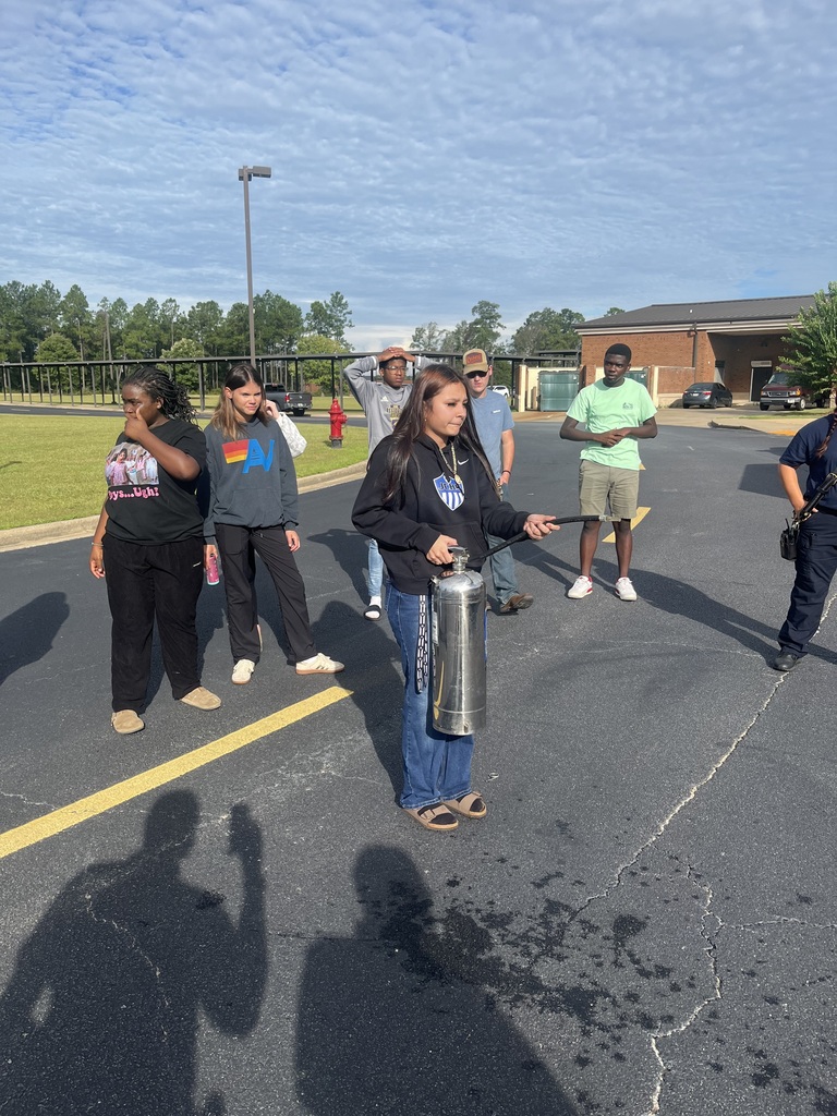 Students in the Introduction to Law and Criminal Justice Essentials classes participate in a hands-on learning experience with City of Bainbridge Fire personnel, practicing fire extinguisher use, exploring a fire truck and its equipment, and learning about fire safety, emergency response, and public safety careers.