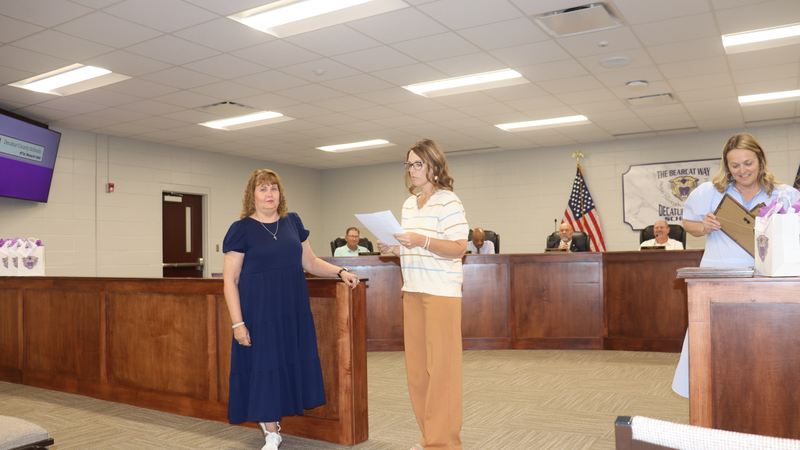 Decatur County Schools staff, students, and community members participate in an awards and recognition ceremony, receiving certificates, plaques, and honors.