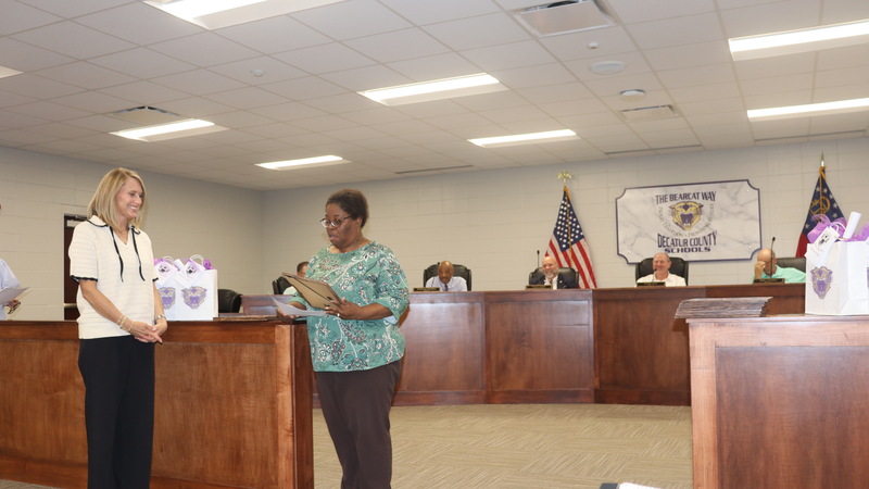Decatur County Schools staff, students, and community members participate in an awards and recognition ceremony, receiving certificates, plaques, and honors.