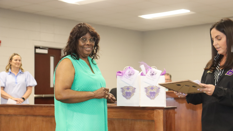 Decatur County Schools staff, students, and community members participate in an awards and recognition ceremony, receiving certificates, plaques, and honors.